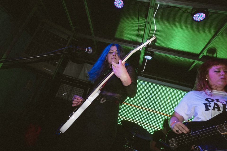 Razor Braids playing, a guitarist with a white guitar raised