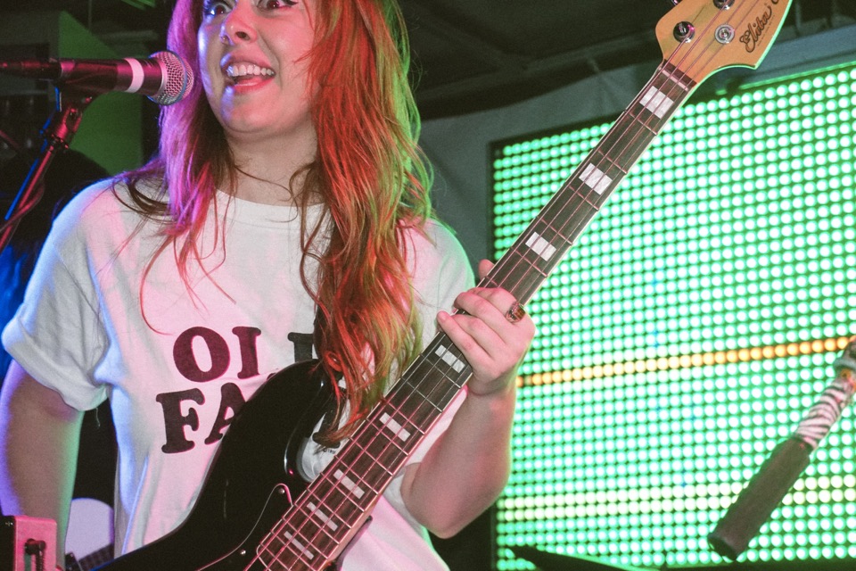 Razor Braids' bassist on stage in front of a green LED wall