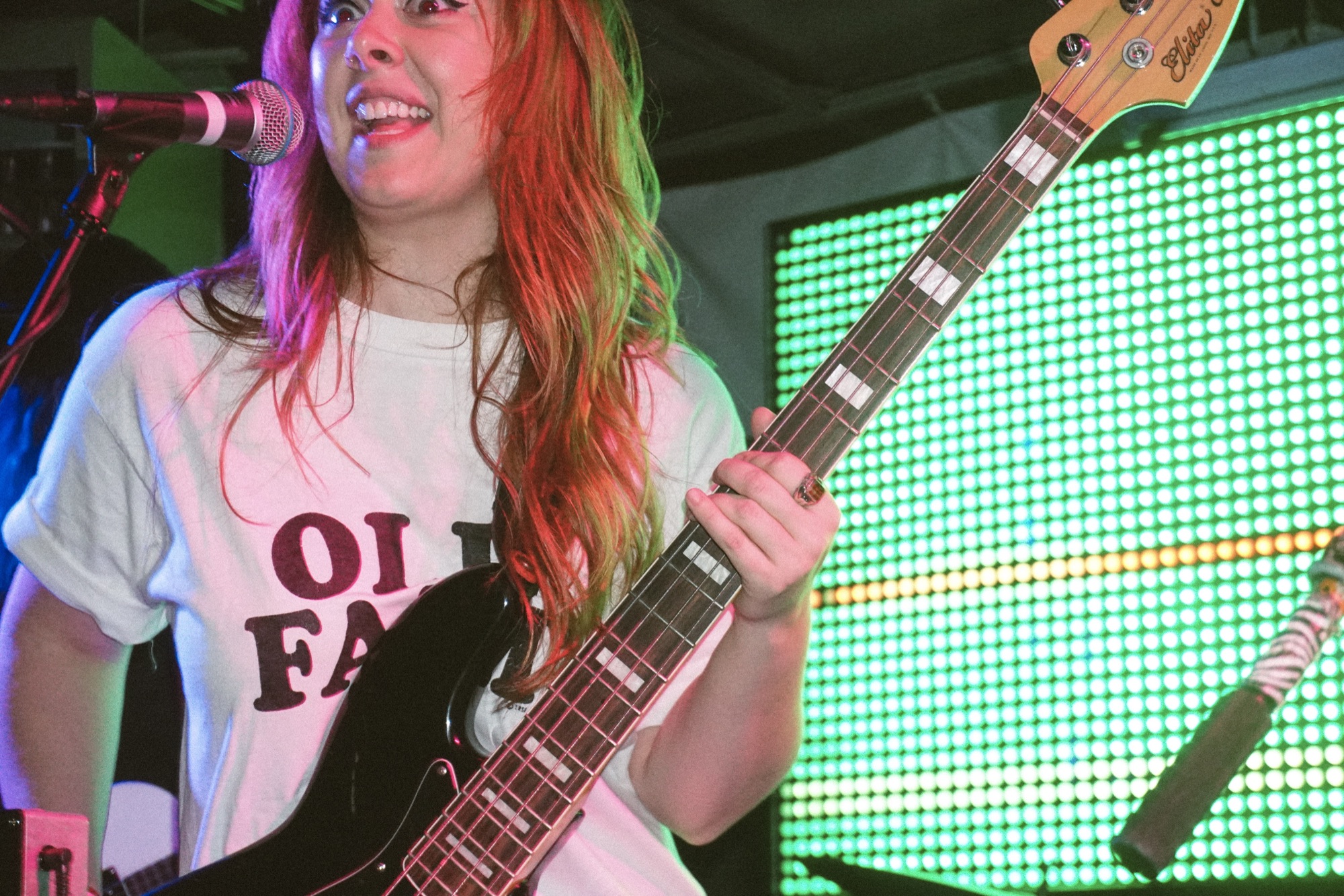 Razor Braids' bassist on stage in front of a green LED wall