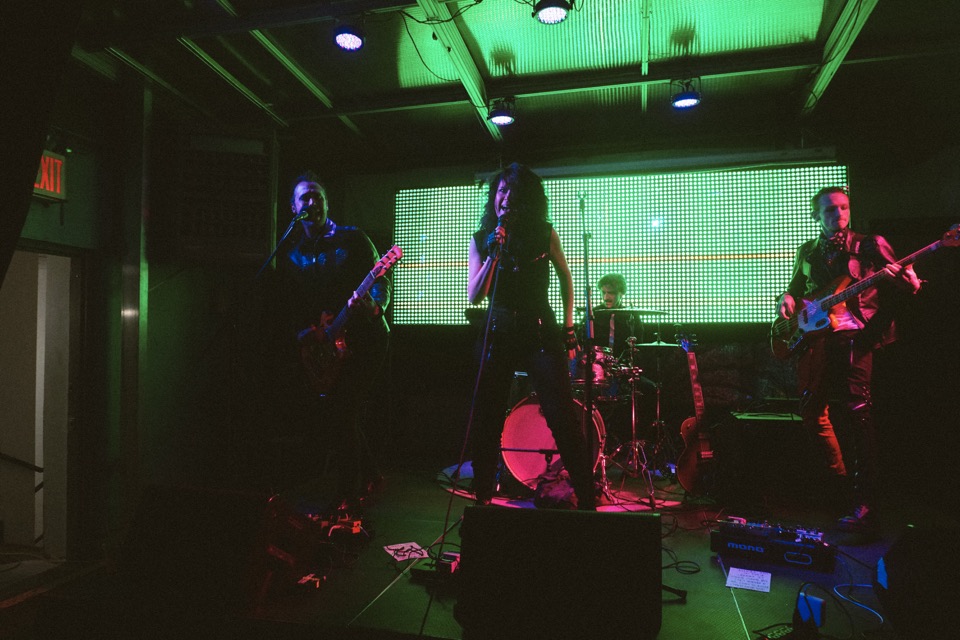 A band on stage under green light
