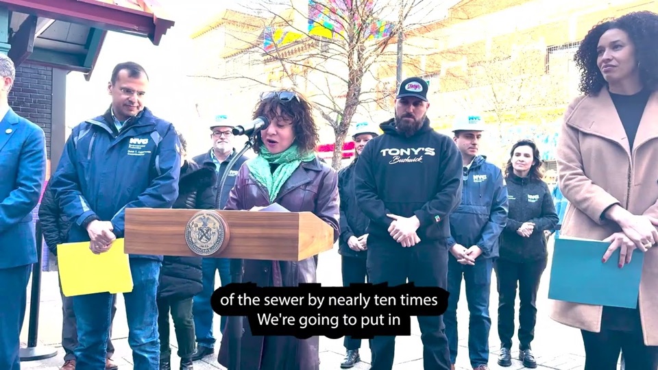 City officials at a podium announcing the sewer project